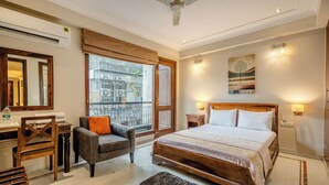 Un dormitorio con cama, escritorio, silla, ventana con vistas y ventilador de techo.