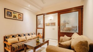 Un salón con sofá, una mesa de centro y una puerta con paneles de vidrio esmerilado.