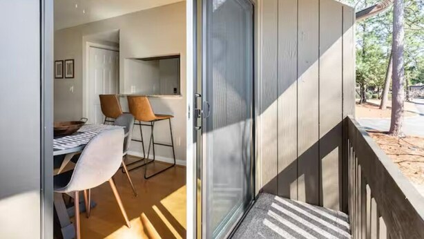Een modern interieur met een eethoek, een schuifdeur naar een terras en uitzicht op de omliggende bomen.