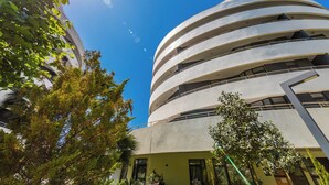 A modern building with a curved facade and multiple balconies.