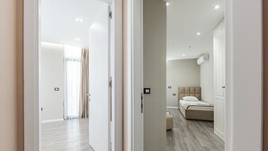 A modern bedroom with a bed, bedside table, and a wardrobe.