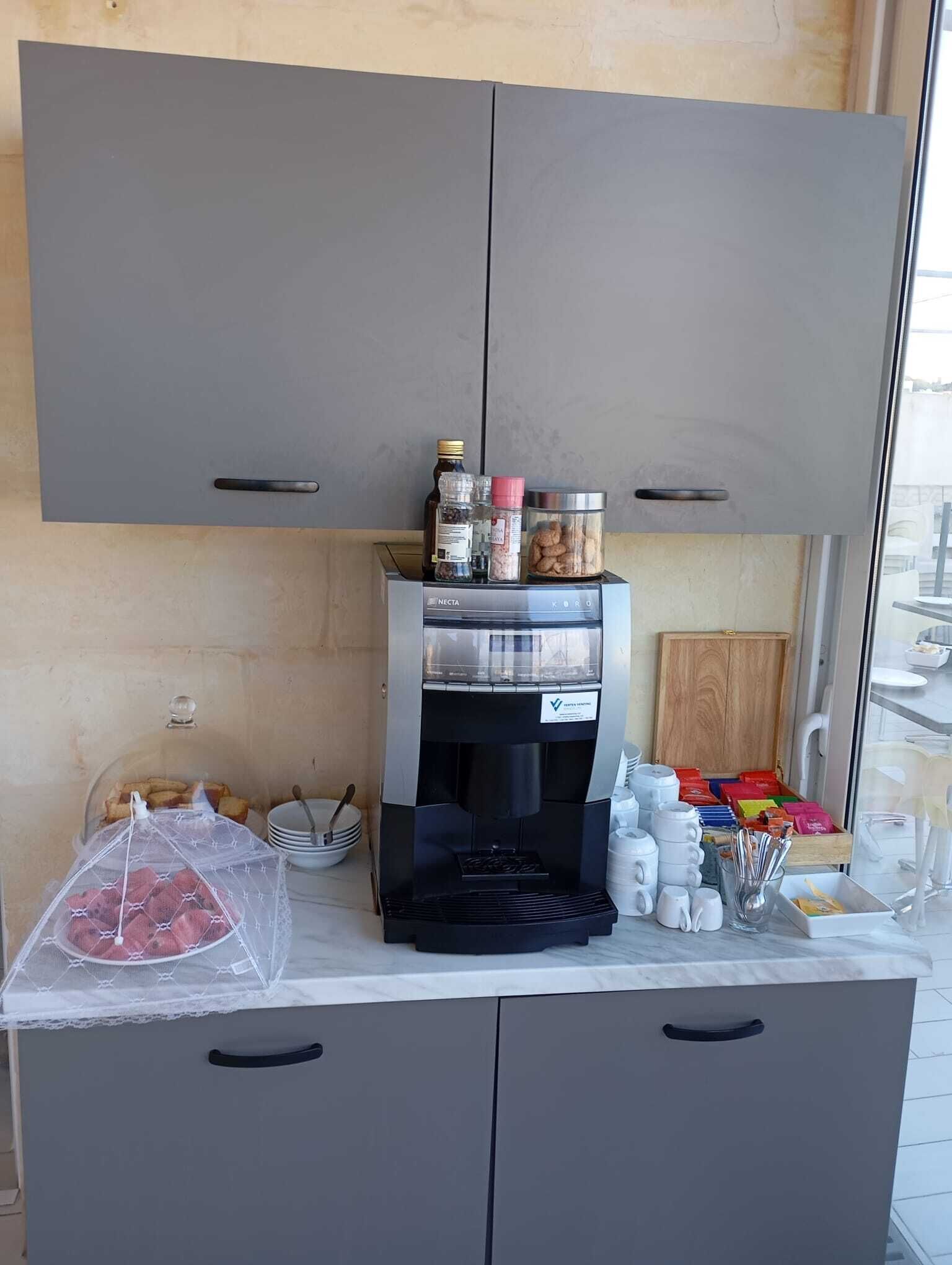 Eine Küchenzeile mit Kaffeemaschine, Stauraumschränken und Blick aus dem Fenster.
