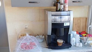 A kitchenette with a coffee maker, a glass of coffee, a food storage bag, and a variety of kitchen utensils. - Villa Del Porto  (Kalkara)