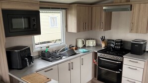 Eine kleine Küche mit Mikrowelle, Toaster, Herd und Backofen.