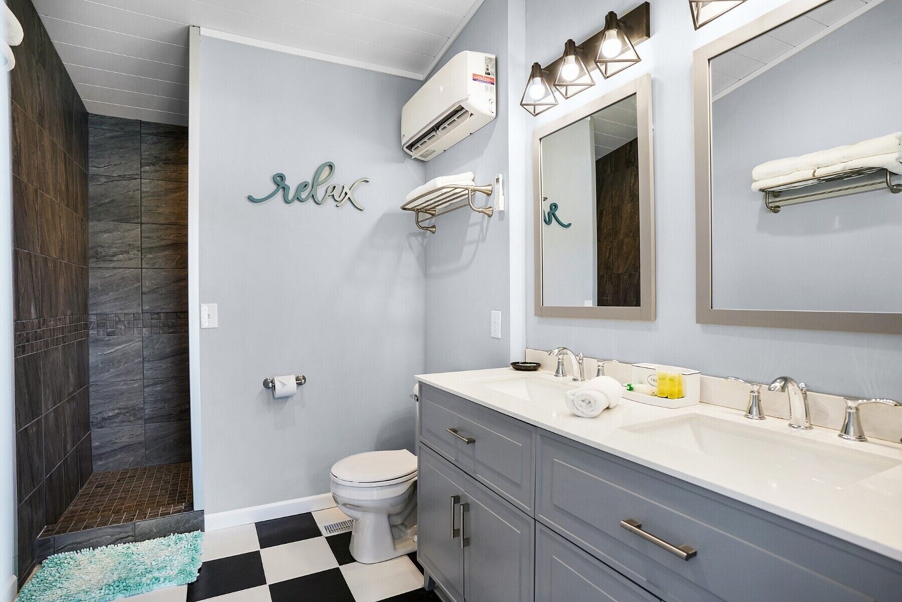 Een badkamer met douche, toilet, wastafel en handdoekhouder.