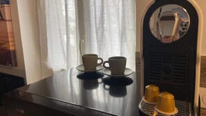 A room with a coffee machine, two cups on a table, and a window with curtains. - Port du Levant (Toulon)