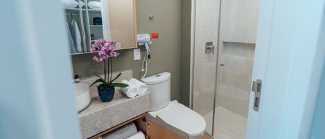 Ein modernes Badezimmer mit integriertem Waschbecken, Toilette und Duschkabine.
