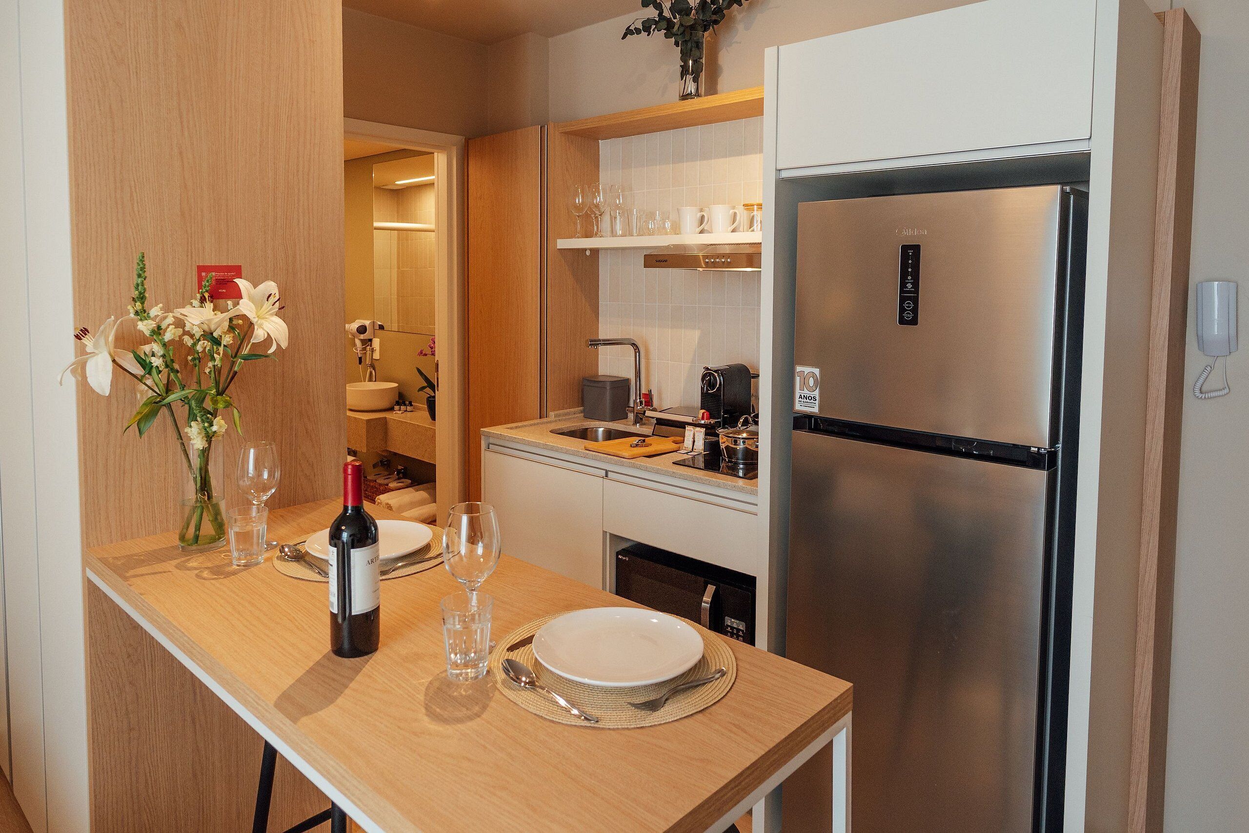 A modern kitchen with a stainless steel refrigerator, wooden countertop, and a vase with flowers.
