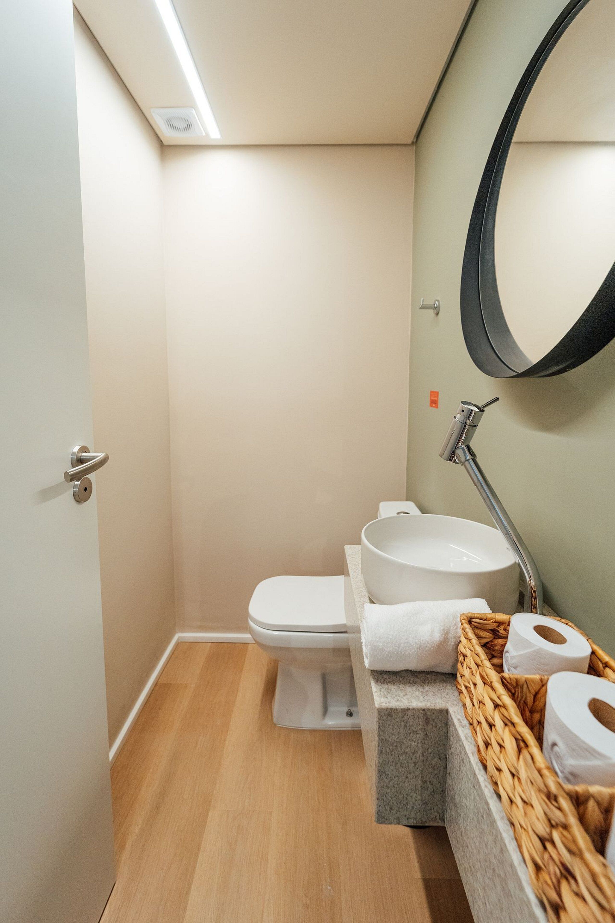 Ein kleines Badezimmer mit Toilette, Waschbecken und Spiegel.