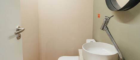 Ein kleines Badezimmer mit Toilette, Waschbecken und Spiegel.