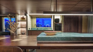 A modern kitchen with a large island, built-in oven, and a view of a cityscape at dusk. - 23 Living (Medellín)