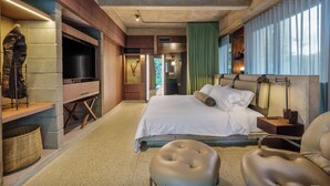 Une chambre d’hôtel moderne dotée d’un grand lit, d’une télévision, d’un bureau et d’un coin salon confortable.