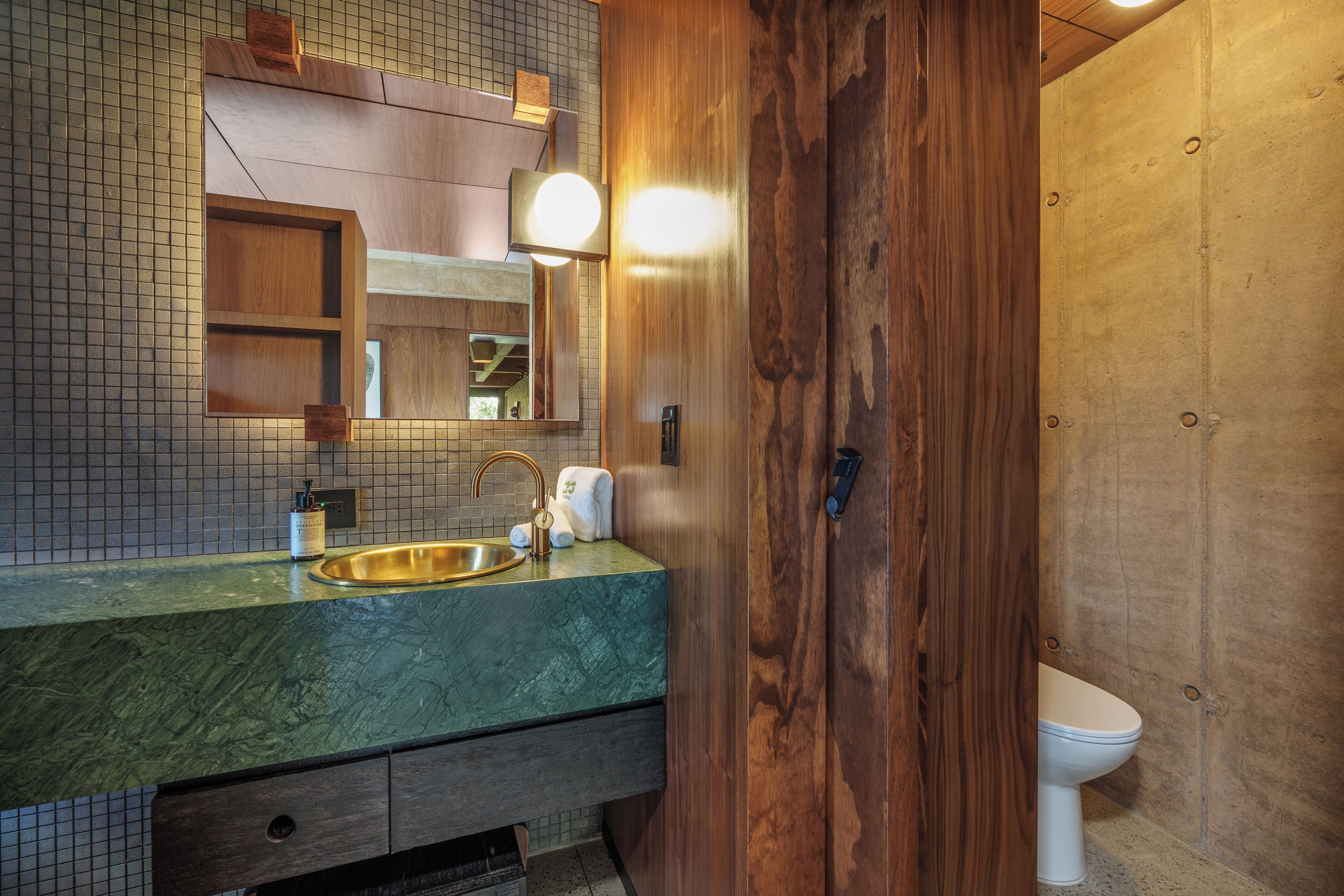 Une salle de bain avec un meuble-lavabo en bois, un évier et des toilettes.