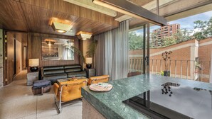 A modern interior with a marble countertop, leather seating, and a view of a brick building through large windows. - 23 Living (Medellín)