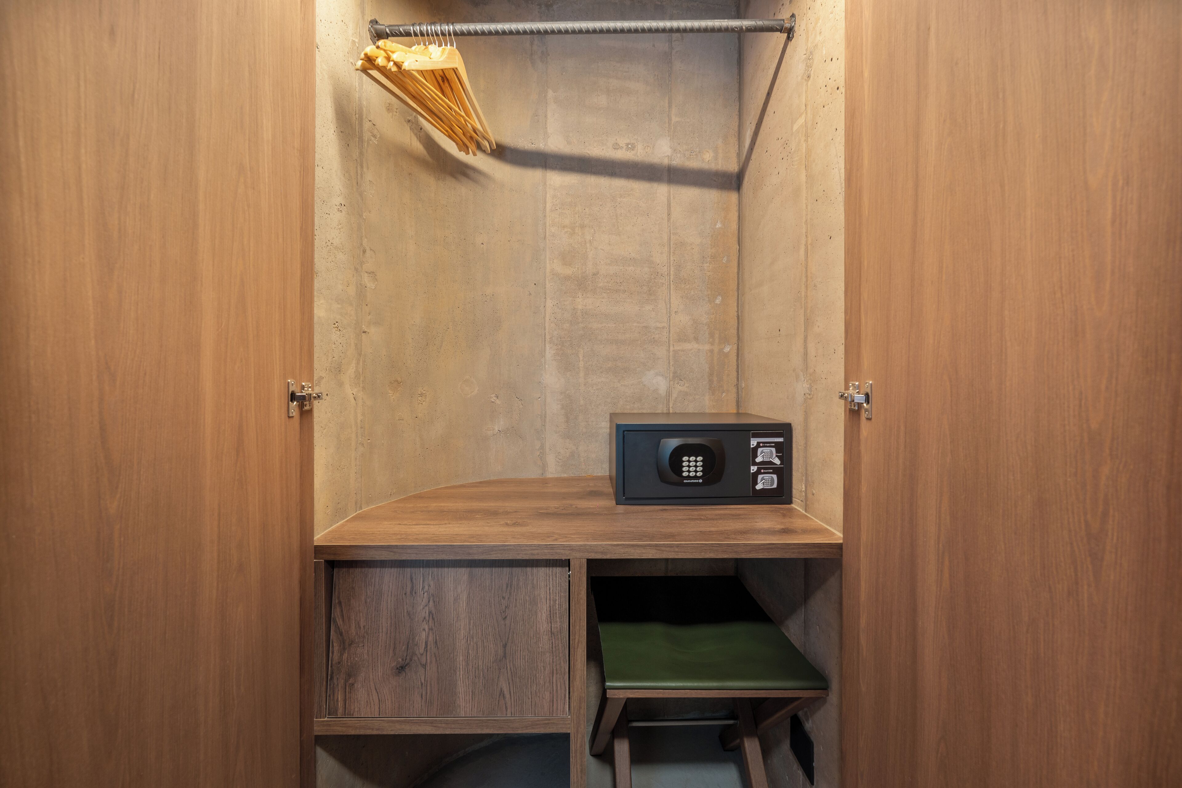 A wooden cabinet with a built-in microwave and a green seat.