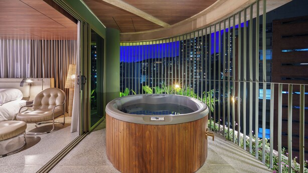 A modern indoor hot tub area with a wooden exterior, a sofa, and a chair. - 23 Living (Medellín)