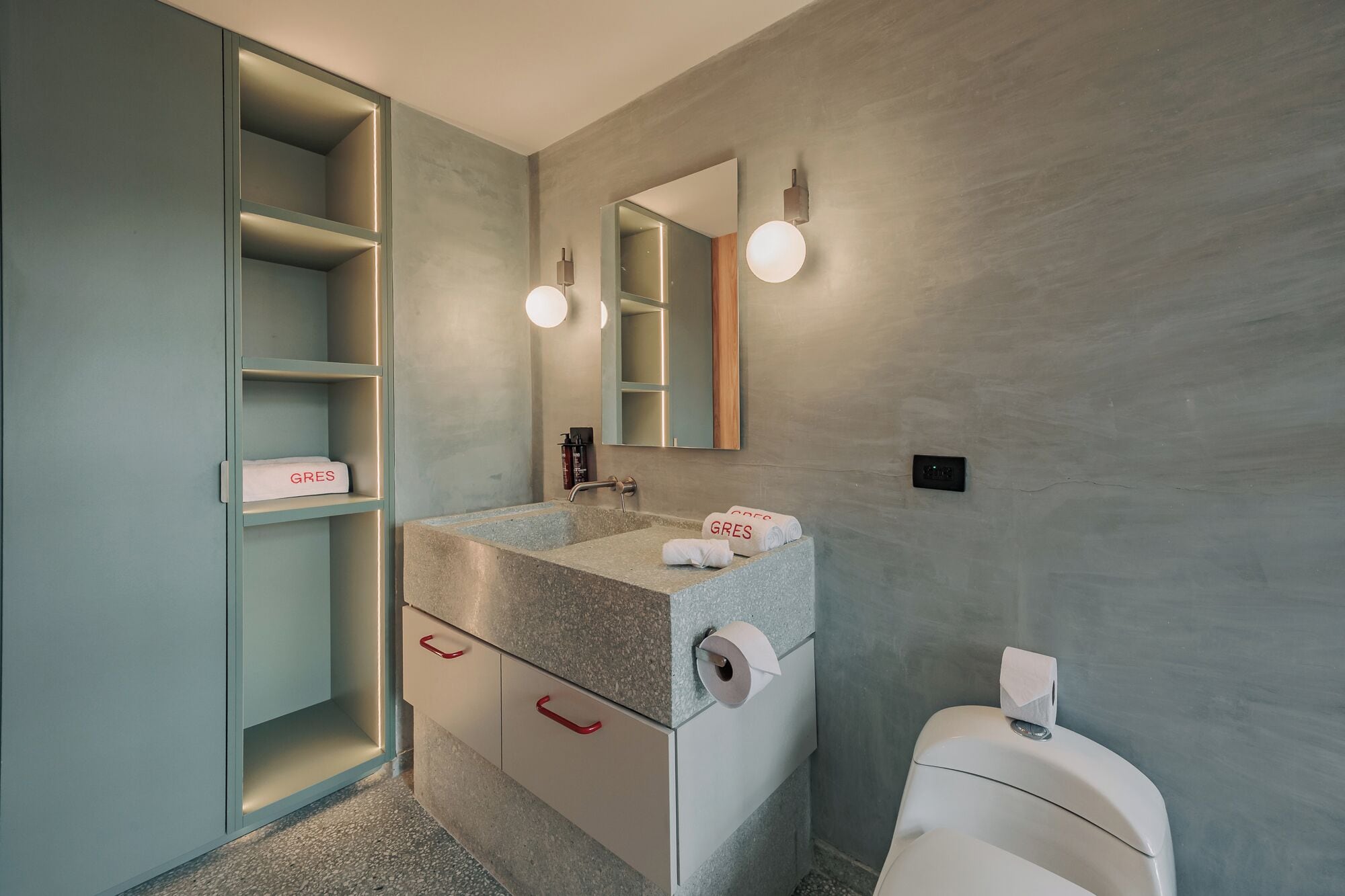 Een moderne badkamer met een inbouwspoelbak, een spiegel en een toilet.