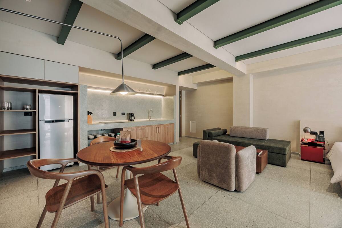 Una cocina moderna con zona de comedor, un sofá y un armario rojo.