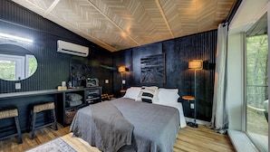 Une chambre à coucher moderne avec un lit, des tables de chevet, un bureau et une grande fenêtre.