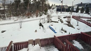 A snowy outdoor area with a wooden deck and a metal fence. - Kazan Hotel Norge (Skien)