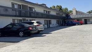 A multi-story motel with a parking lot. - WESTERN STATESINN (San Miguel)