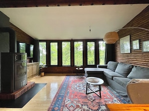 Relax in this inviting living room with a sofa, coffee table, and TV, set against a backdrop of wooden paneling.