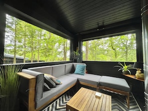 Relax in a serene space with a sofa, coffee table, and lush forest views.