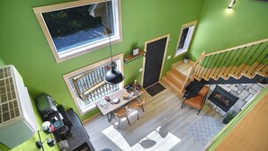 A modern interior with a dining area, kitchen, and staircase. - 2 Level Cabin w/Hot Tub & Fireplace. 1.5 Bathrooms, 2 Queen Beds (Ashland)