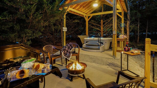 A covered outdoor seating area with a hot tub, a fire pit, and a grill. - 2 Level Cabin w/Hot Tub & Fireplace. 1.5 Bathrooms, 2 Queen Beds (Ashland)