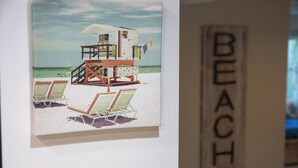 Ein Rettungsschwimmturm mit Liegestühlen und einer Flagge an einem Sandstrand.
