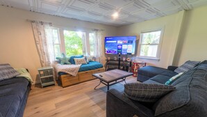 Ein gemütliches Wohnzimmer mit einem Bett, einer Couch und einem Fernseher.