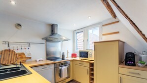 A modern kitchen with a stove, oven, microwave, and a coffee maker. - Le Cocon Alsacien - Appt authentique coeur strasbourg (Strasbourg)
