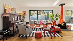 A living room with a piano, a sofa set, a coffee table, and a fireplace.