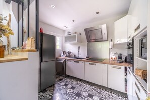 Enjoy cooking in this well-equipped kitchen with a refrigerator, dishwasher, and microwave.