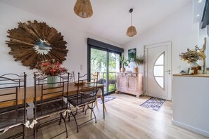 Enjoy meals in this dining area with a large window offering a view of lush greenery.