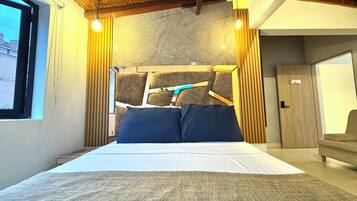 A modern bedroom with a large bed, wooden headboard, and a view of the city through a window.