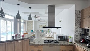 Una cocina moderna con gabinetes de madera, encimera de granito y estufa a gas integrada.