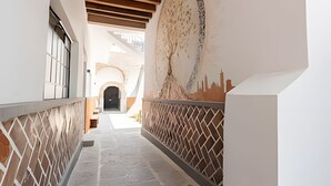 A corridor with a tiled floor, a wooden ceiling, and a mural on the wall. - Casona 212 | Stylish Loft w/ High-Speed WiFi (Puebla)