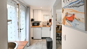 A modern kitchen with white cabinets, a microwave, and a dishwasher.