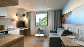 A modern kitchen with a dining area, a sofa, and a window with curtains. - Paulette 14 - A Sables d'Or les pins, proche plage (Fréhel)