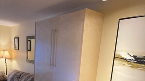 A hotel room with a dining table, chairs, a bed, a sofa, and a painting on the wall. - John's Aspens Ski In/Out (Whistler)