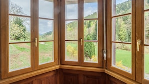 Habitación de esquina con ventanas amplias y detalles de madera.