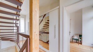 Un intérieur moderne avec un escalier en bois, une porte coulissante et un fauteuil.
