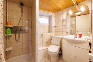 A bathroom with a shower, toilet, and sink.