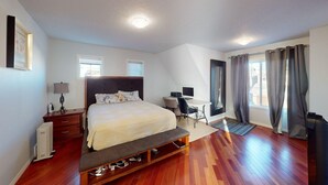 A bedroom with a bed, desk, and chair, a radiator, and a window with curtains. - Cozy&comfy family size house. Beautiful location, near COP. Pet friendly &Clean. (Calgary)
