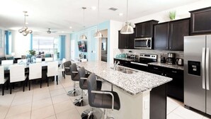 A modern kitchen with dark cabinets, stainless steel appliances, and a granite countertop. - A Little Galaxy Far Far Away (Davenport)
