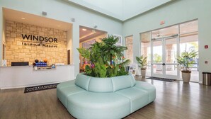 A reception area with a light blue sofa, a brick wall with 'WINDSOR Island Resort' signage, and potted plants. - A Little Galaxy Far Far Away (Davenport)