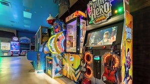 A row of arcade machines with vibrant, colorful designs and various game titles. - Rendezvous at Regal Palms - Nearby Theme Parks! (Davenport)