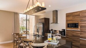 A modern kitchen with a central island, stainless steel appliances, and wooden cabinetry.