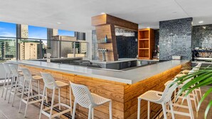 Une cuisine moderne dotée d’un îlot central, de tabourets de bar et offrant une vue sur le paysage urbain.